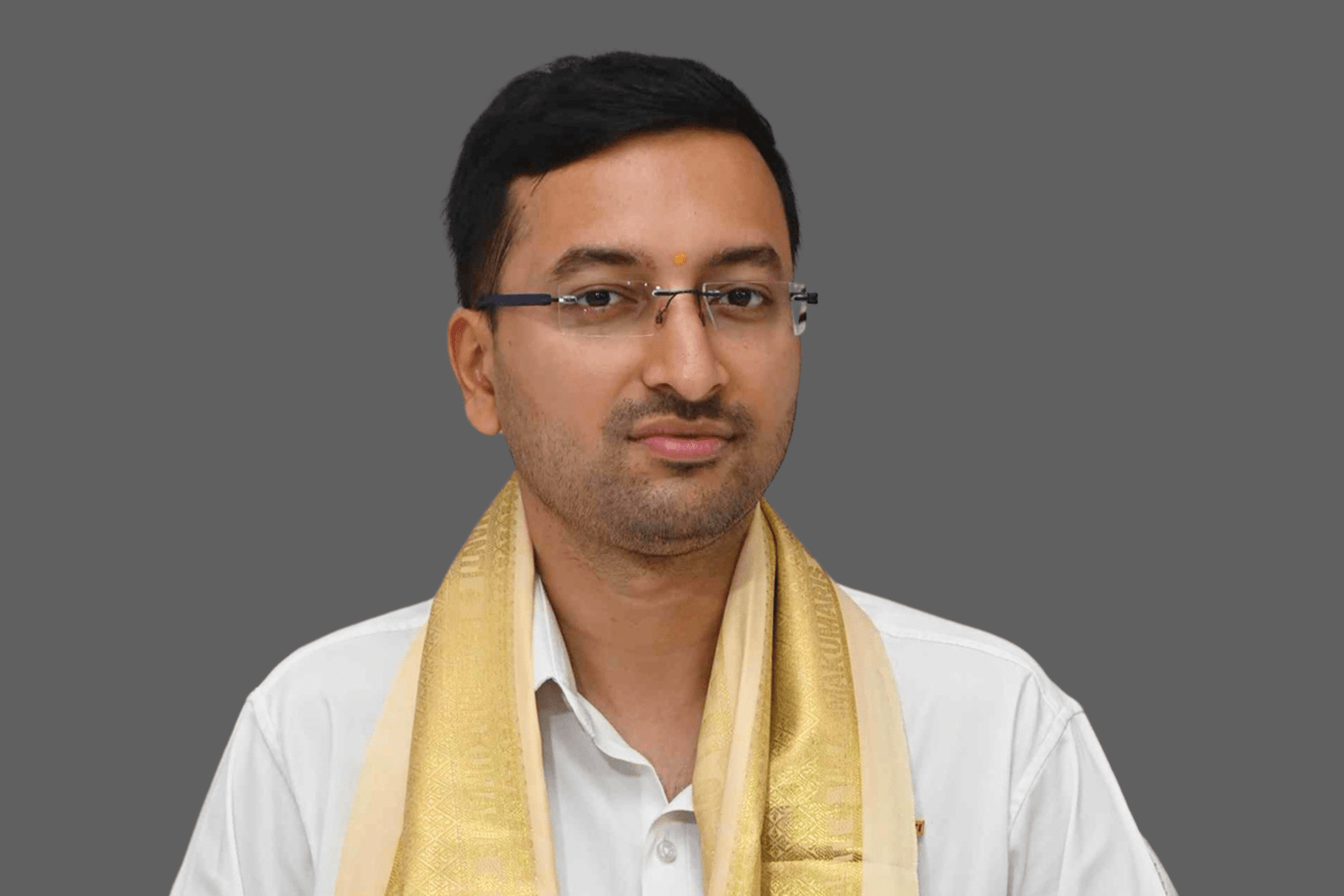 Portrait of Yash Agrawal, Founder and Secretary of Divine Sanskarshala Foundation, wearing glasses and a golden traditional stole over a white shirt.