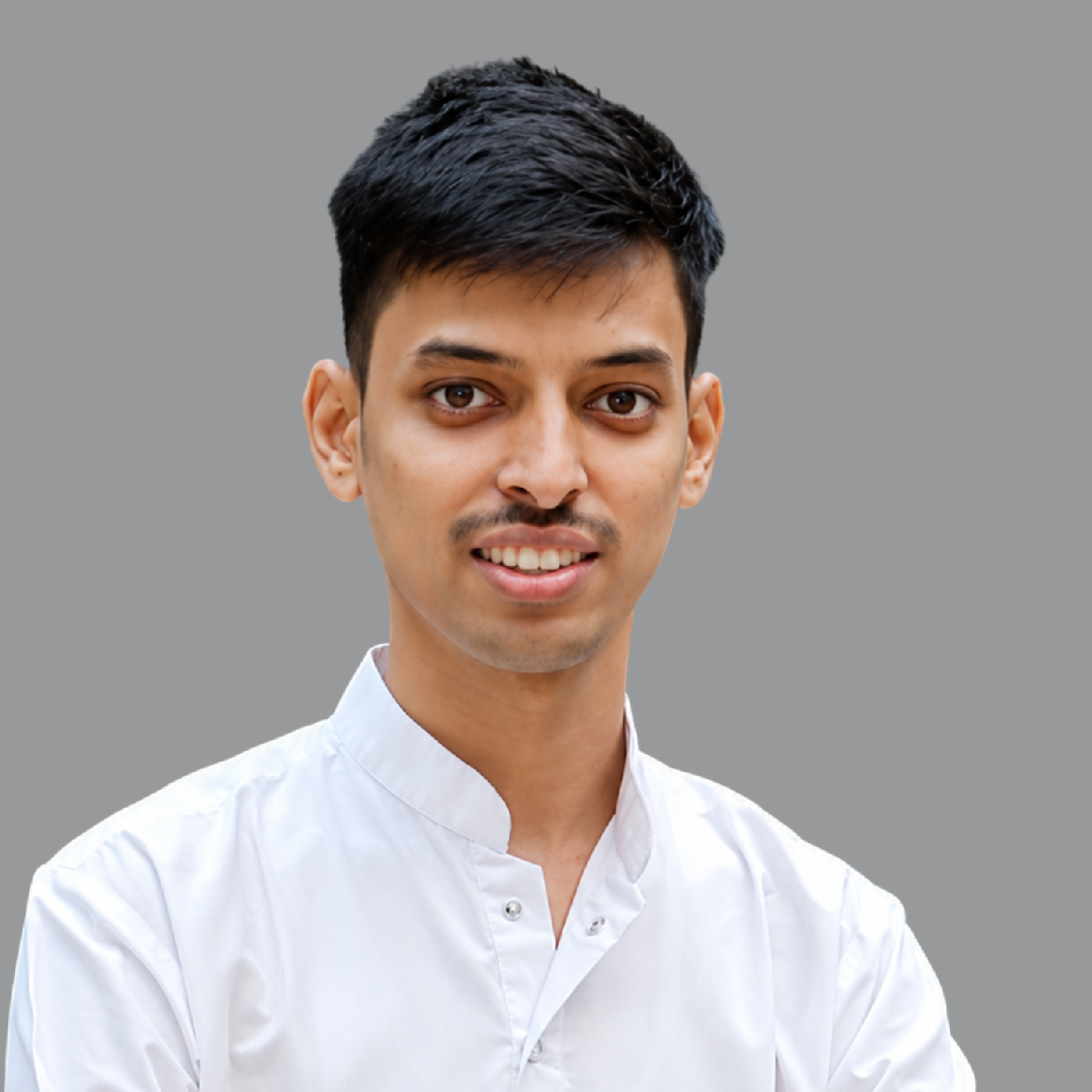 Portrait of Harsh Agrawal, Treasurer of Divine Sanskarshala, wearing a white traditional kurta and smiling confidently against a clean grey background.