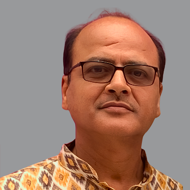 Portrait of Yash Nagar, Core Member of Divine Sanskarshala, wearing glasses and a patterned traditional kurta against a plain grey background.