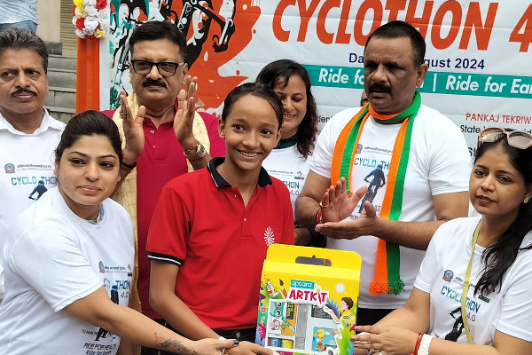 Ashok Tiwari, Mayor of Varanasi, felicitating a student from Divine Sanskarshala during the Cyclothon 4.0 event, as participants and organizers applaud in the background.