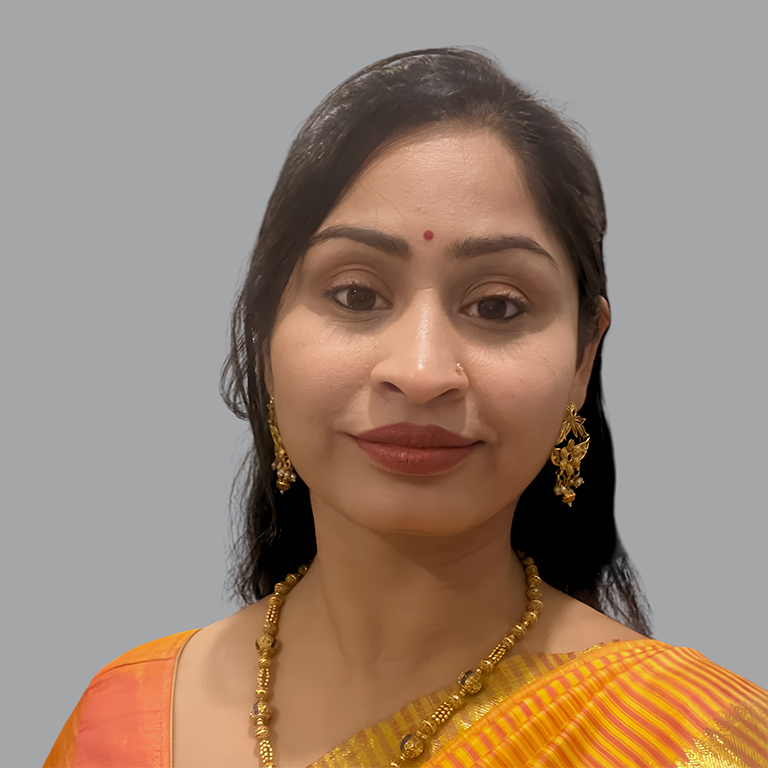 Portrait of Priti Somani, Executive Member of Divine Sanskarshala, wearing a traditional orange silk saree with gold jewelry, smiling gracefully with a bindi, representing the organization's leadership and commitment to social service.
